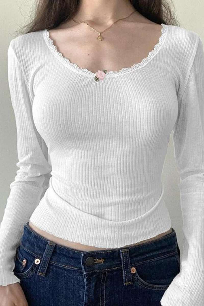 Shows a white plain cotton long sleeved top with a rose detail on the middle